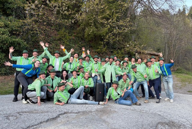 Team we enable climbers in Oostenrijk met groene overhemden en hoedjes